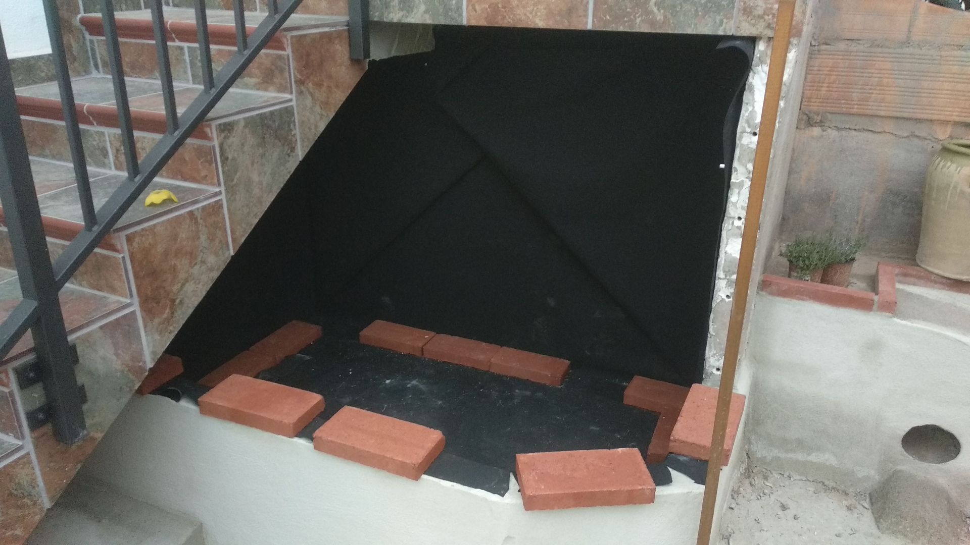 Una escalera con ladrillos en los escalones y una barandilla de metal.