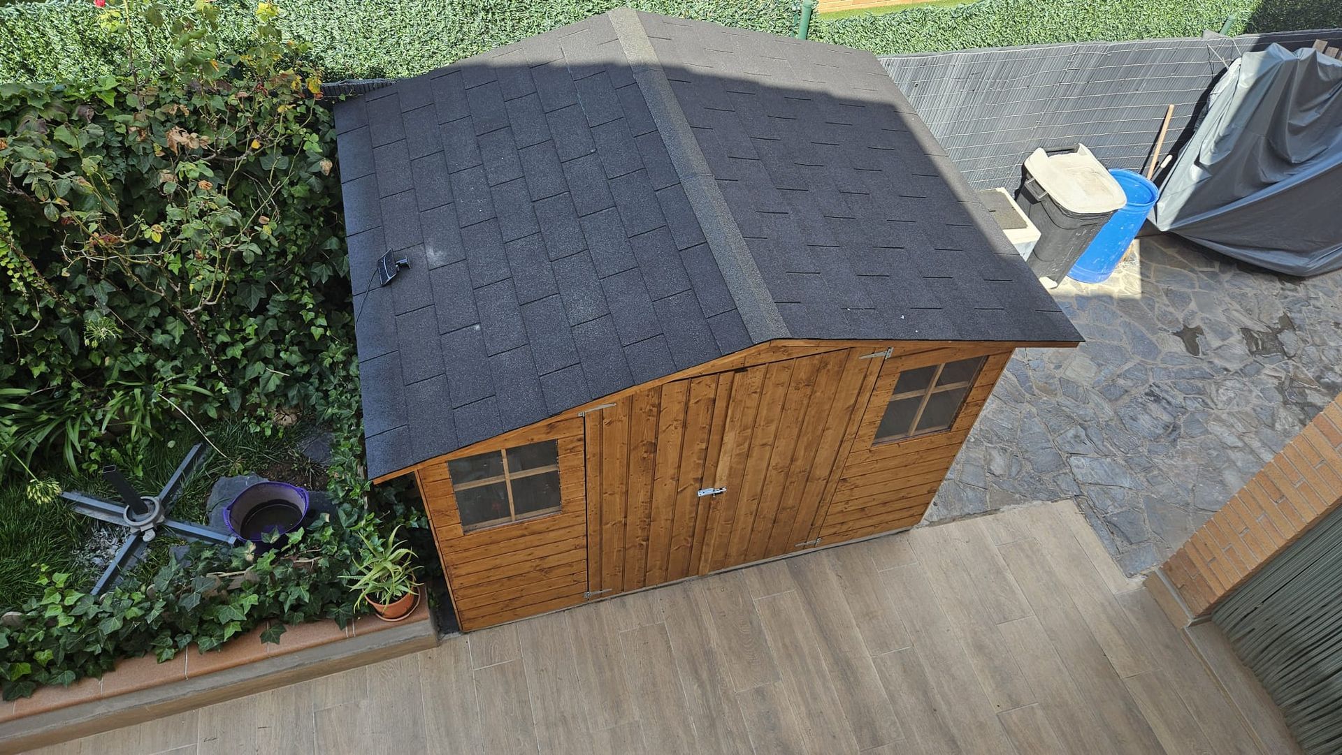 Una vista aérea de un cobertizo de madera con techo negro.