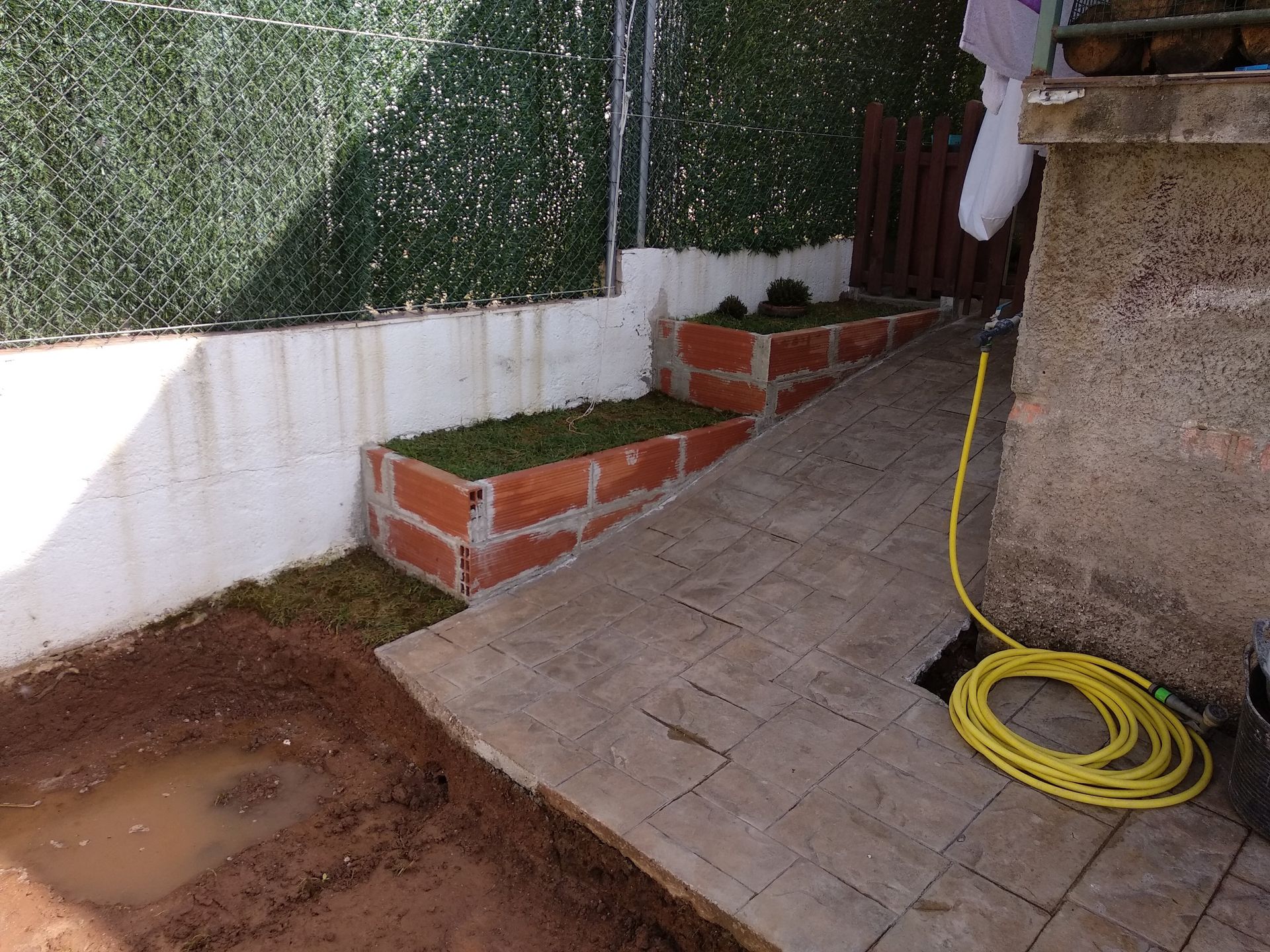 Una manguera amarilla está conectada a una pared de ladrillos.