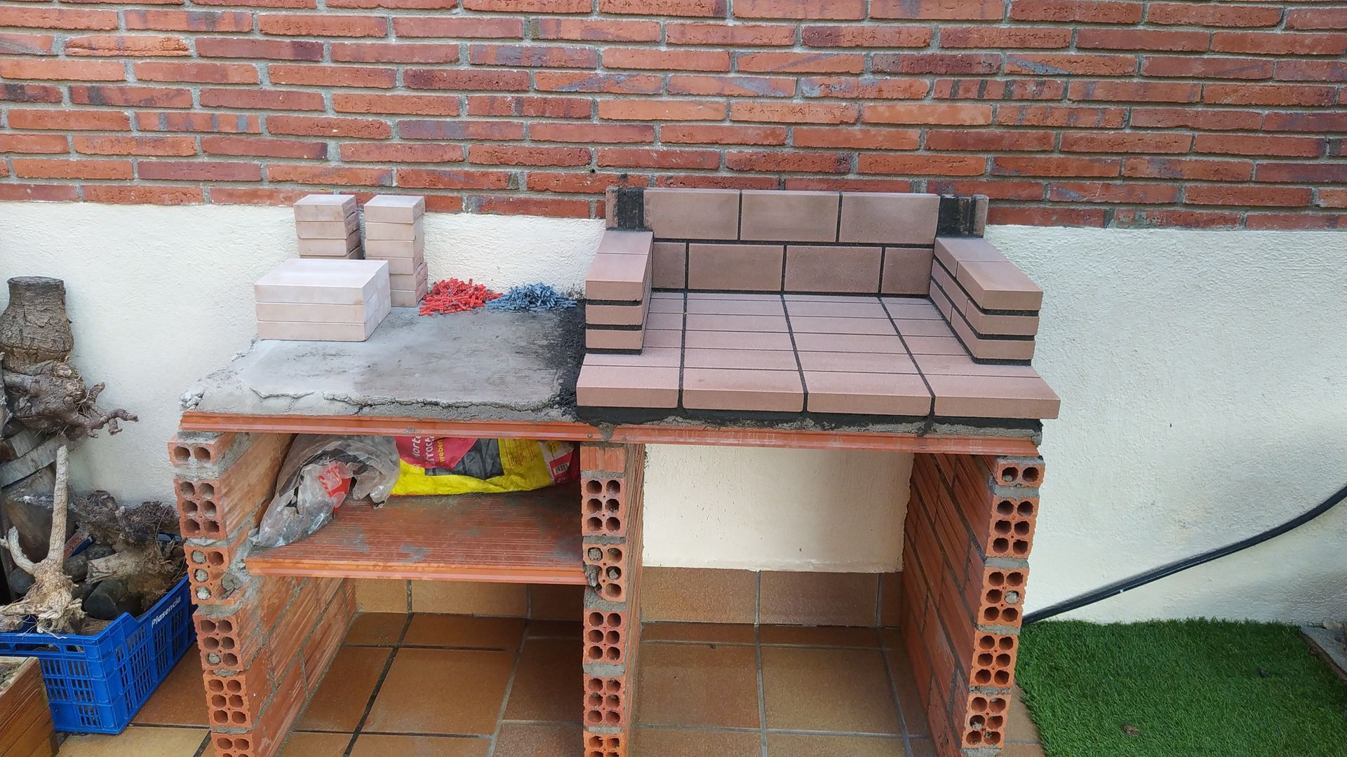 Se está construyendo una mesa de ladrillos frente a una pared de ladrillos.