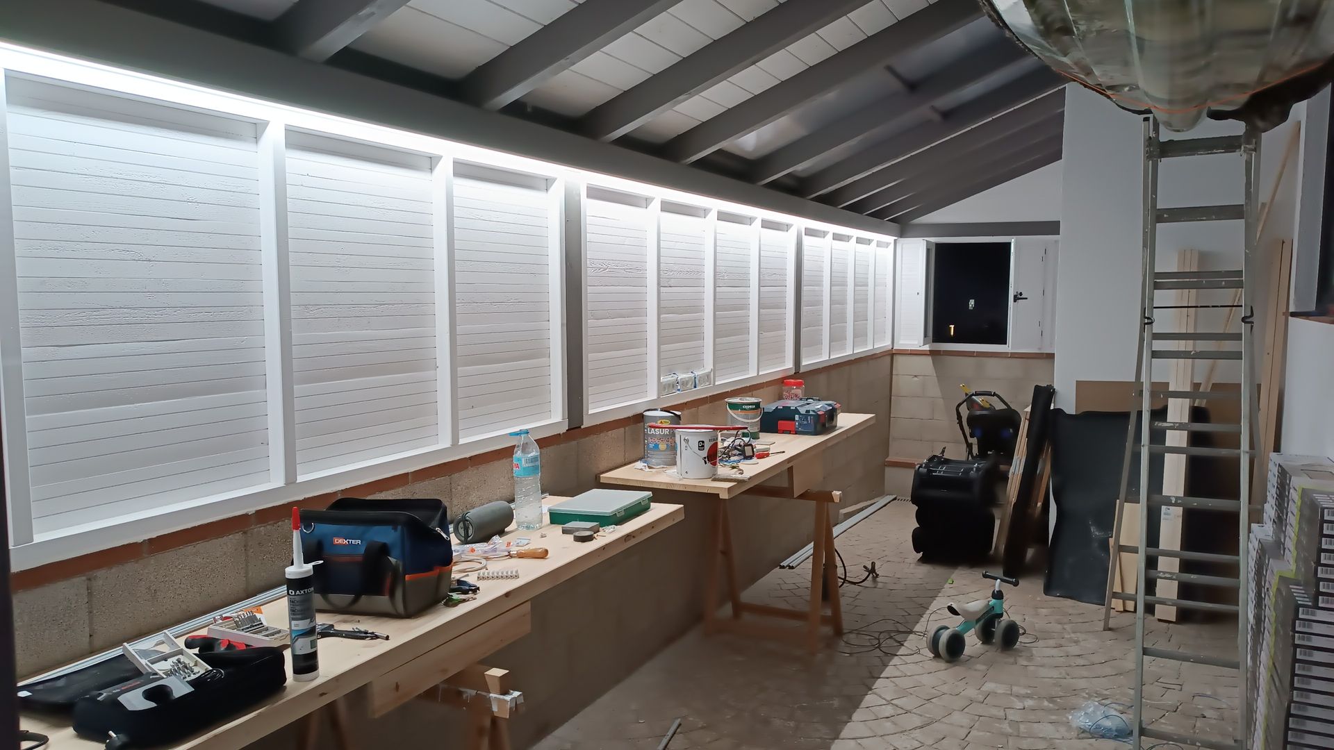 Una habitación con muchas mesas y una escalera dentro.