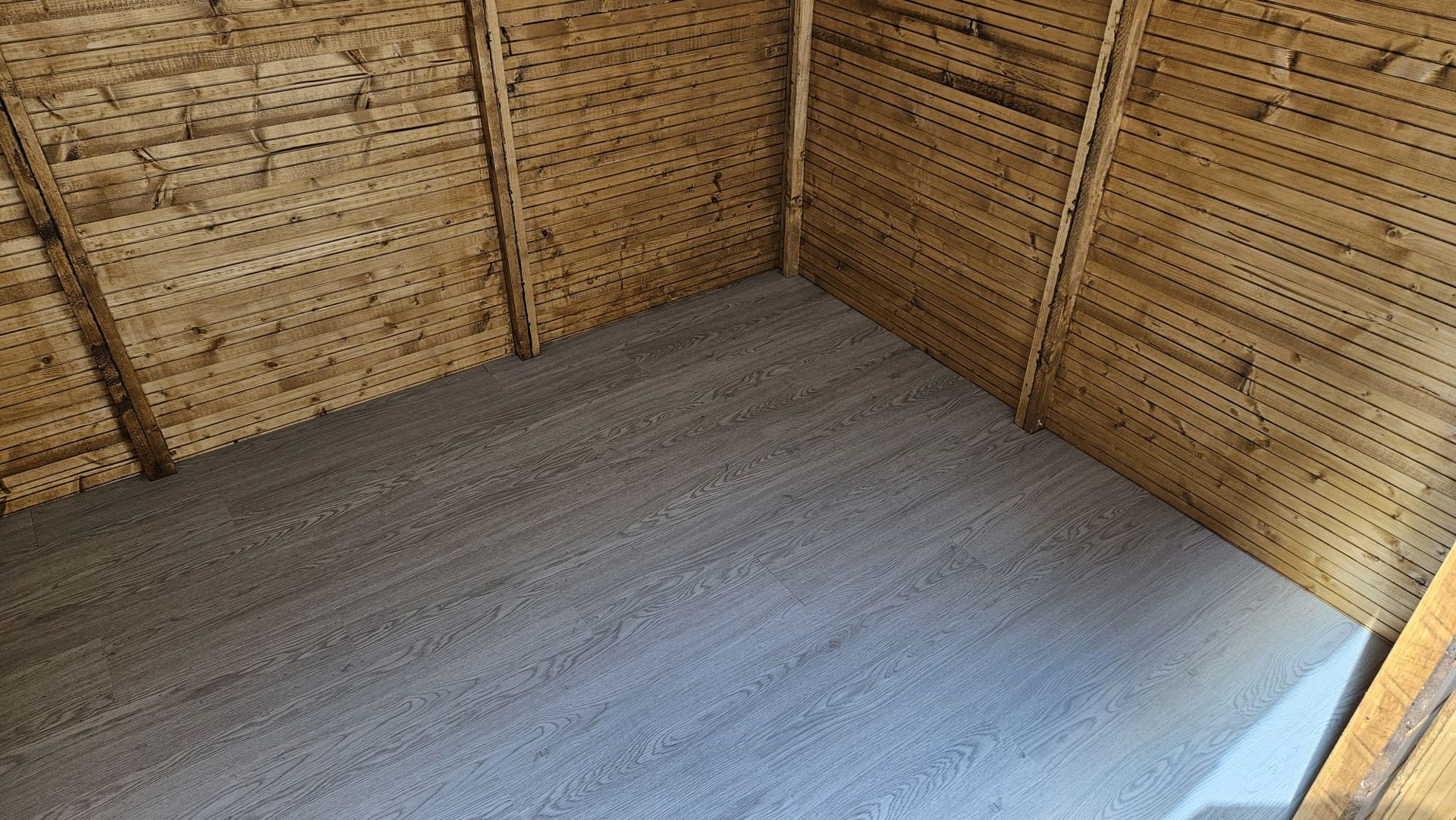 Una pequeña habitación con suelo alfombrado y paredes de madera.