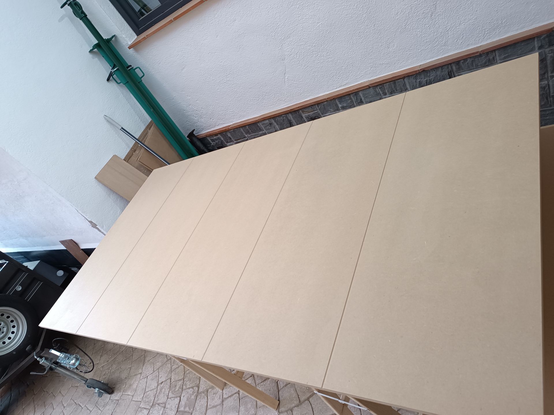 Una mesa de cartón está en una habitación junto a una tubería verde.