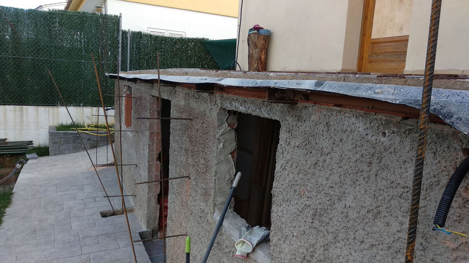 Un edificio en construcción con una escalera y un trapeador al costado.