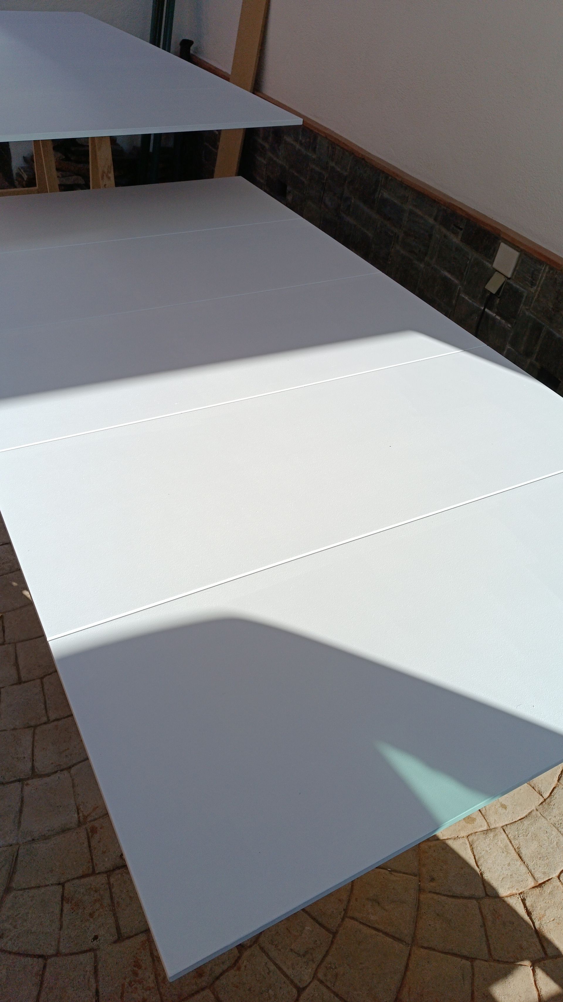 Una hoja de papel blanca reposa sobre un piso de ladrillos.