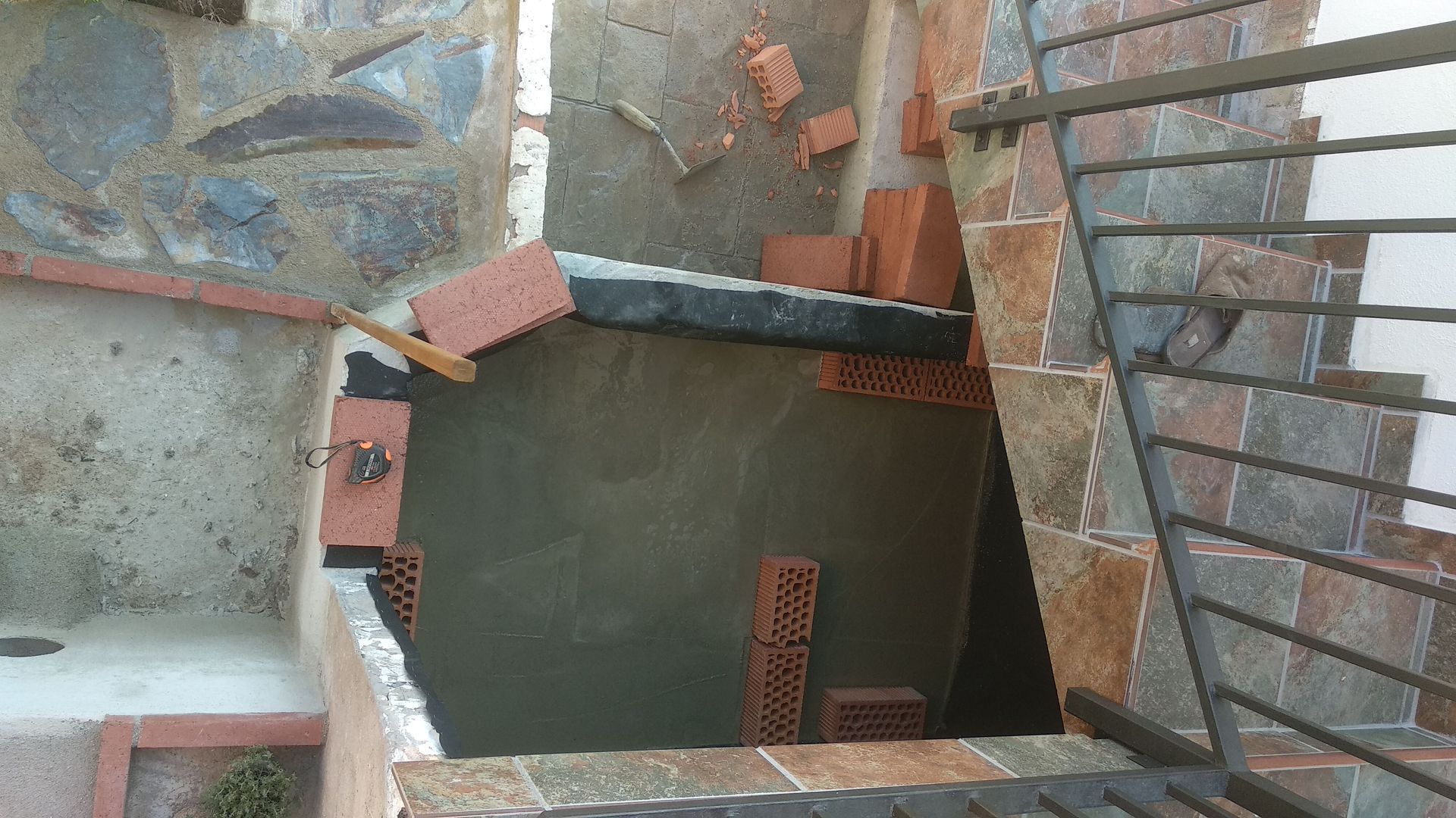 Se está construyendo una escalera con ladrillos y barandilla de metal.