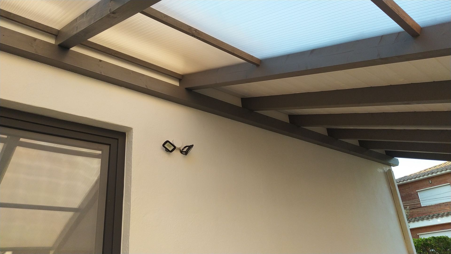 Una pared blanca con una ventana y un techo.