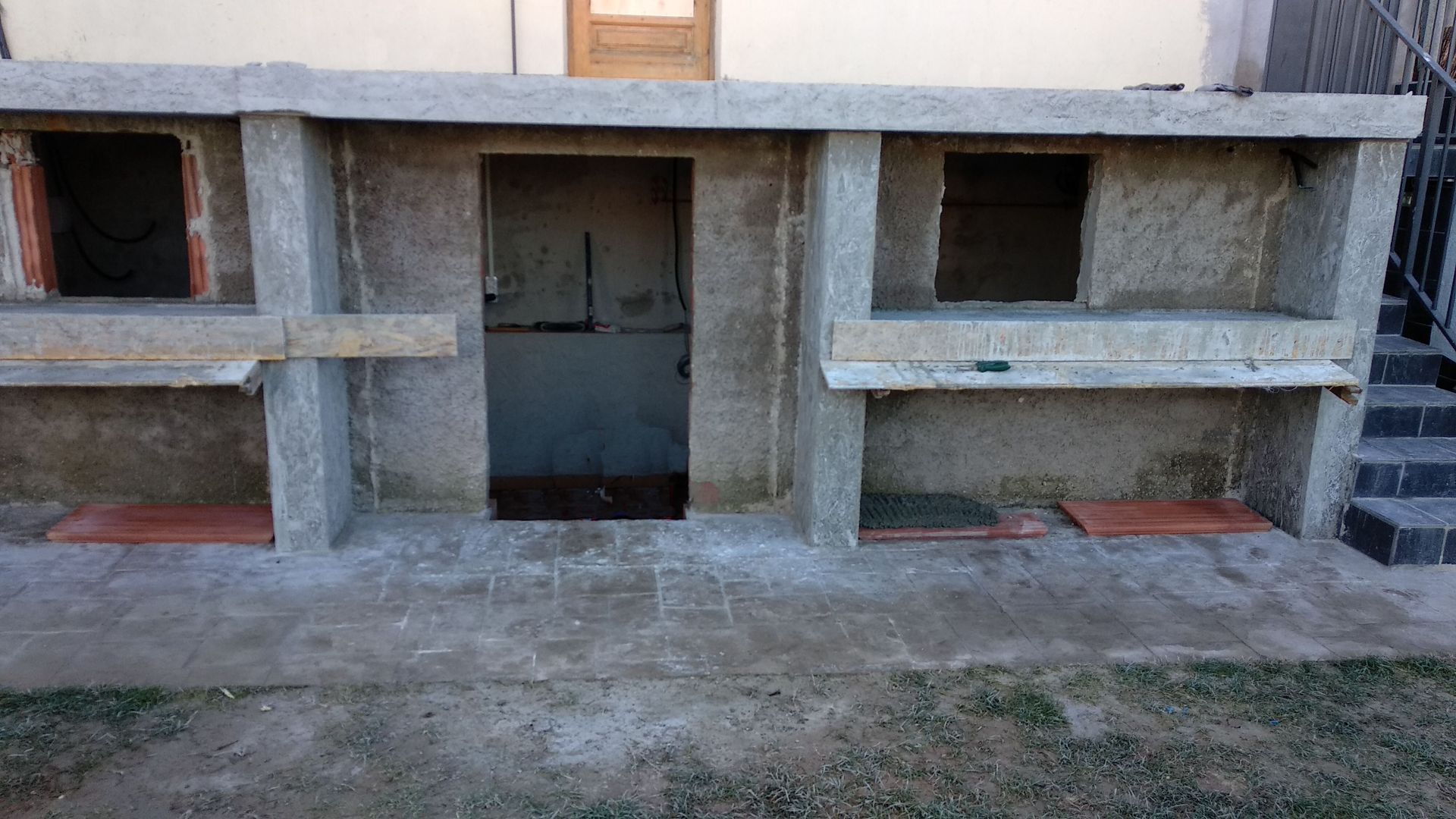 Una estructura de hormigón con una puerta y escaleras delante de un edificio.