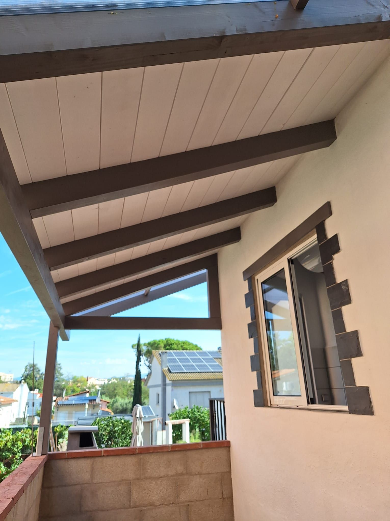 Un balcón con una ventana y un techo encima.