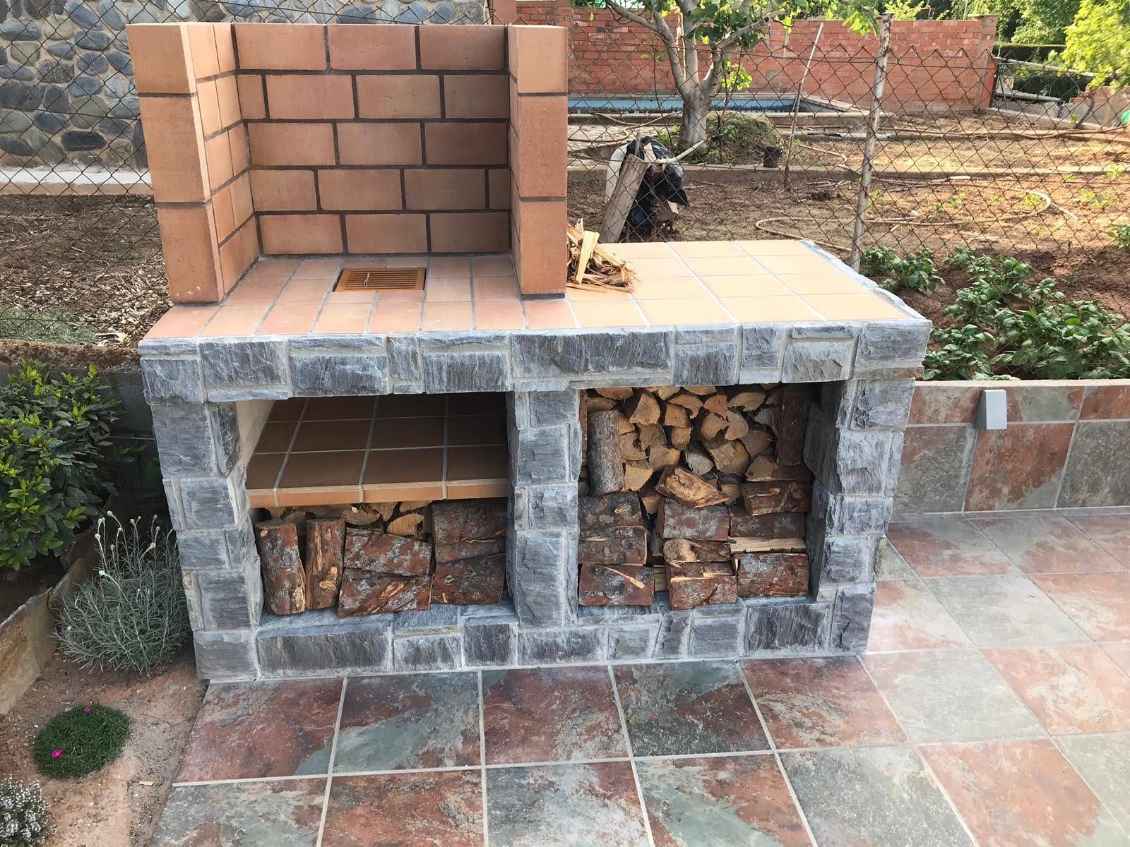 Una chimenea de ladrillo con un montón de troncos dentro