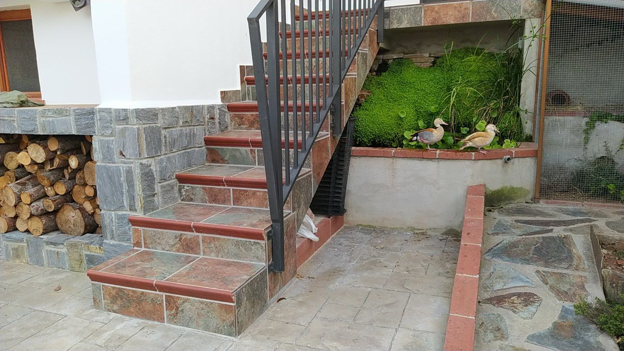 Un conjunto de escaleras que conducen a una casa con una barandilla de metal.
