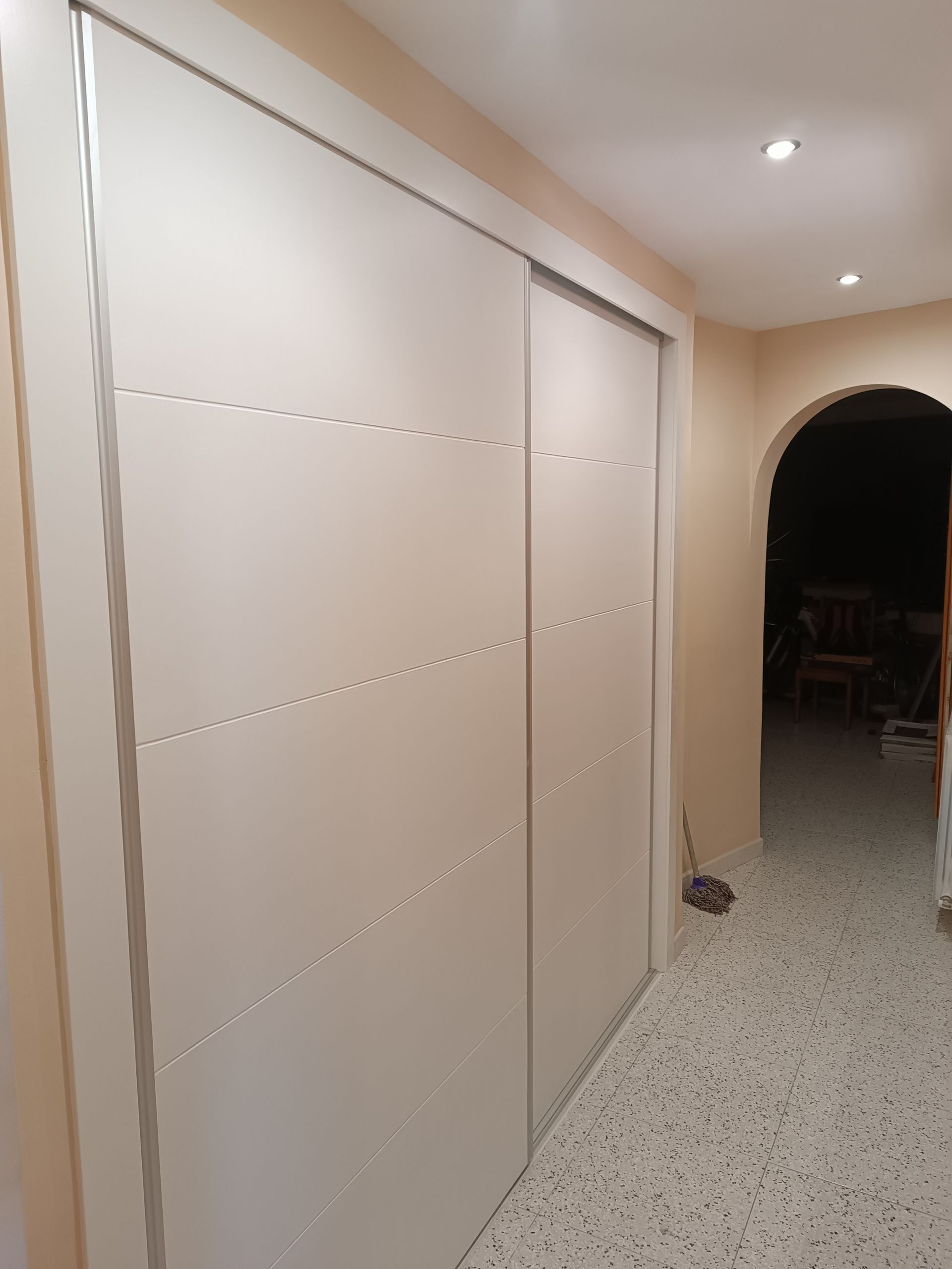 Un pasillo con un armario con puertas correderas en el medio.