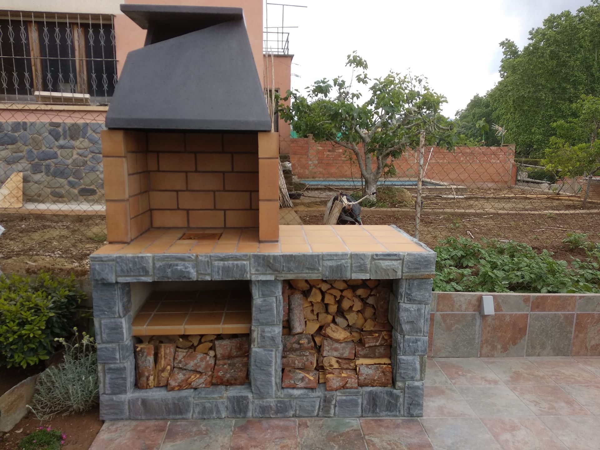 Una barbacoa de ladrillo con una chimenea encima