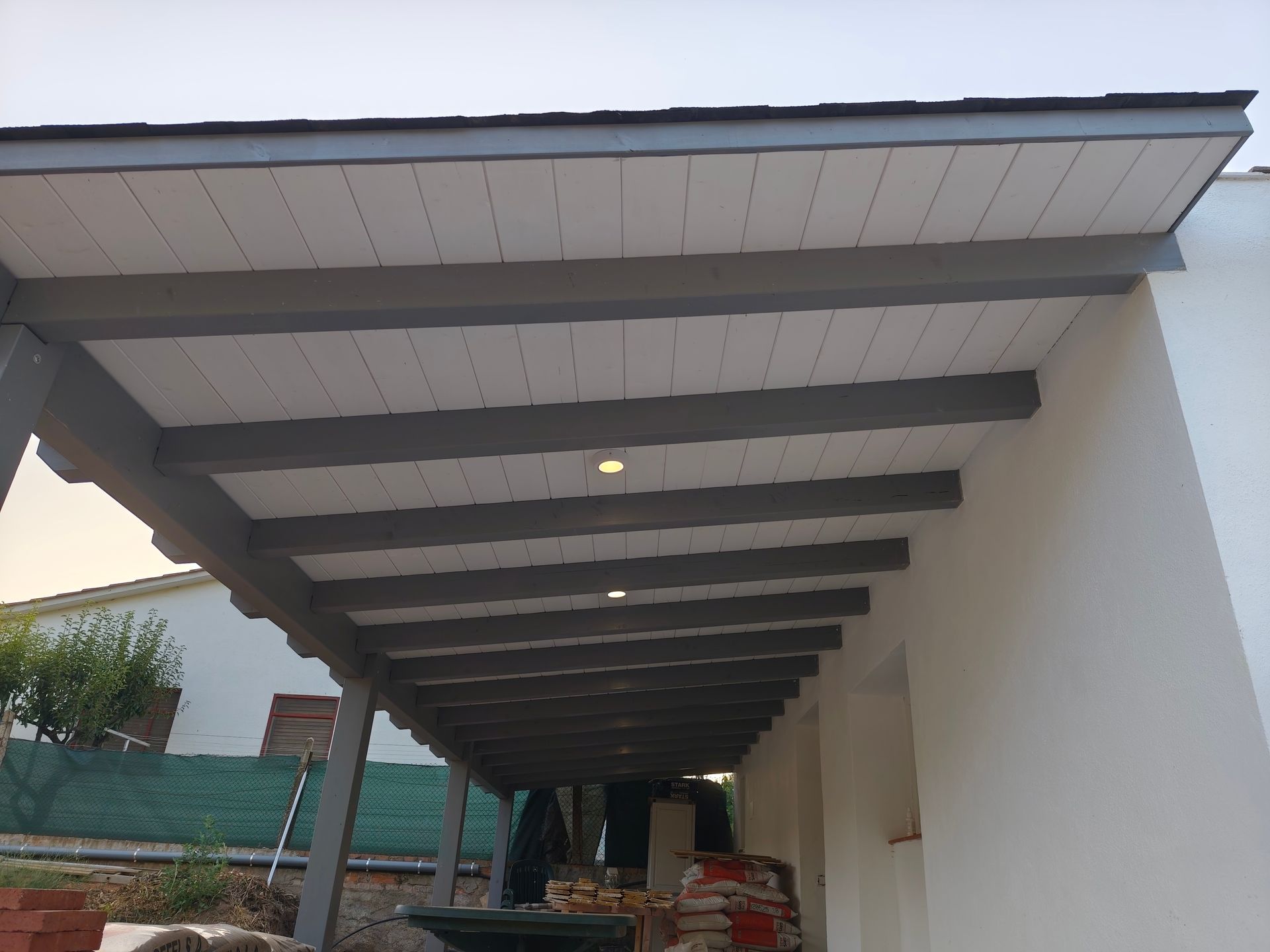 Un edificio blanco con un techo cubierto de vigas de madera.