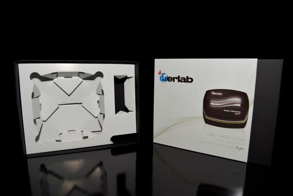 Boîte de produit partiellement ouverte avec un insert moulé et une photo du produit sur la couverture.