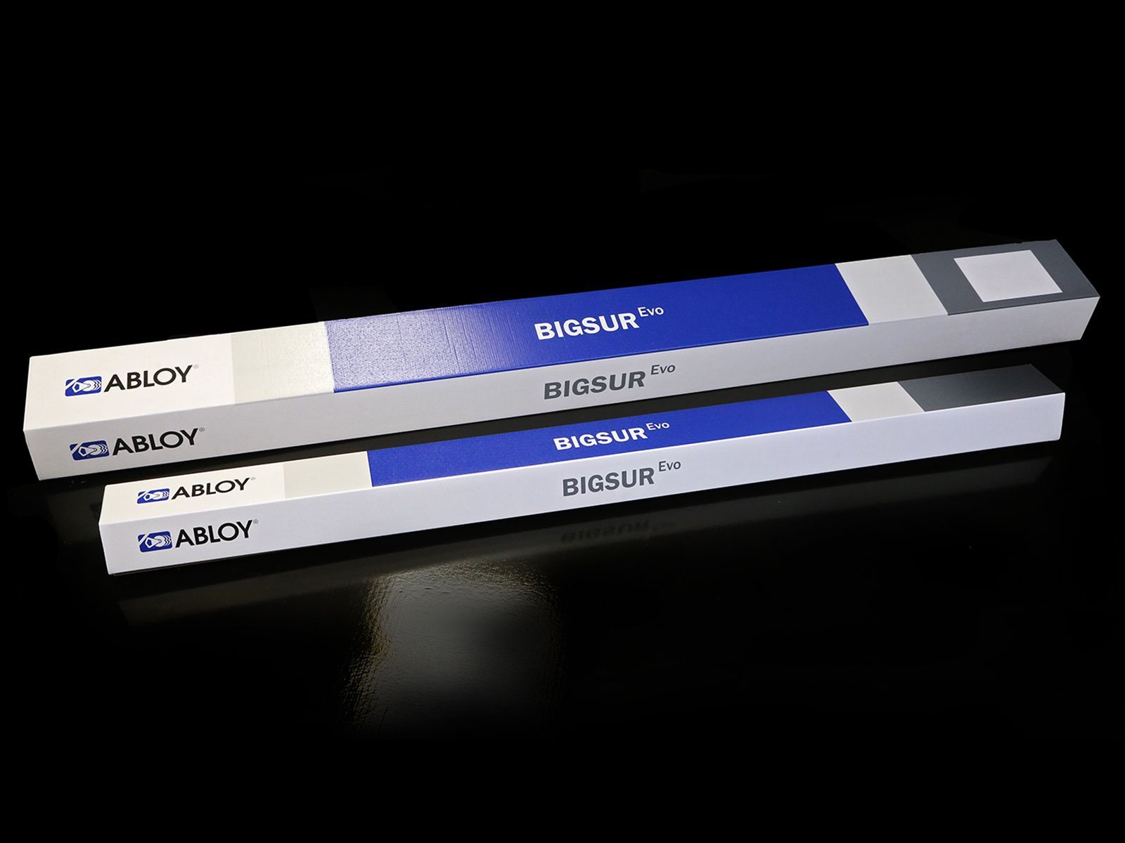 Deux boîtiers rectangulaires ABUS, portant l'inscription « BIGSUR », sur une surface noire réfléchissante.