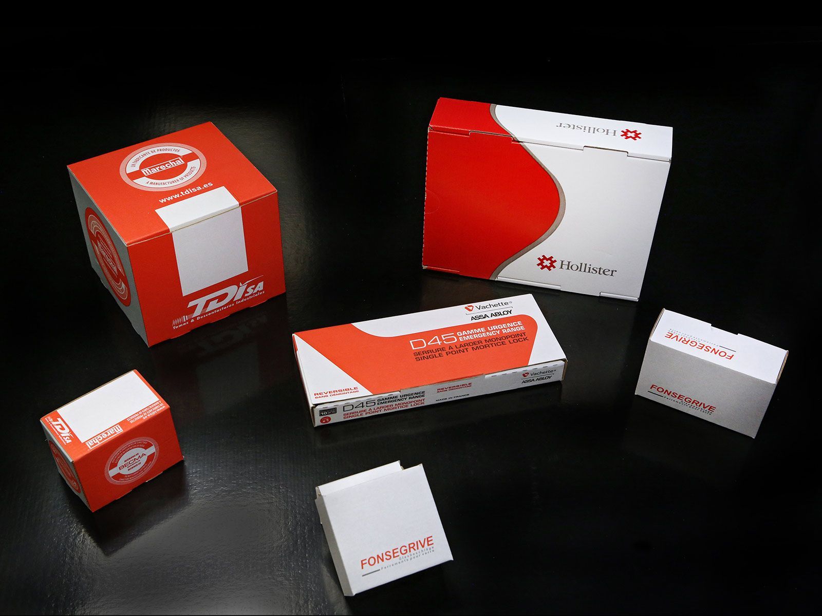 Assortiment de boîtes de produits rouges et blanches sur fond noir.