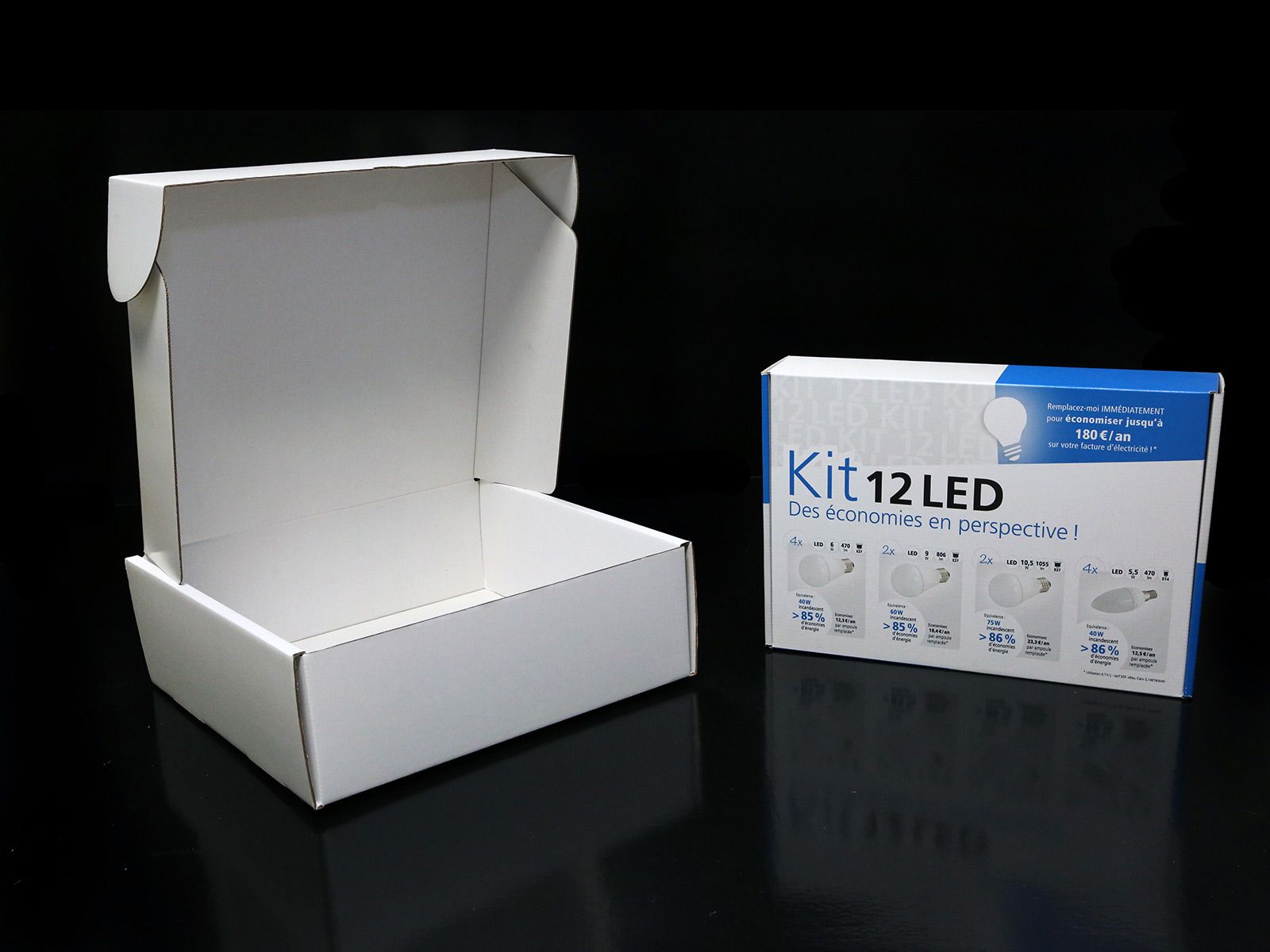 Une boîte en carton blanc ouverte à côté d'une boîte étiquetée « Kit 12 LED » sur une surface noire.