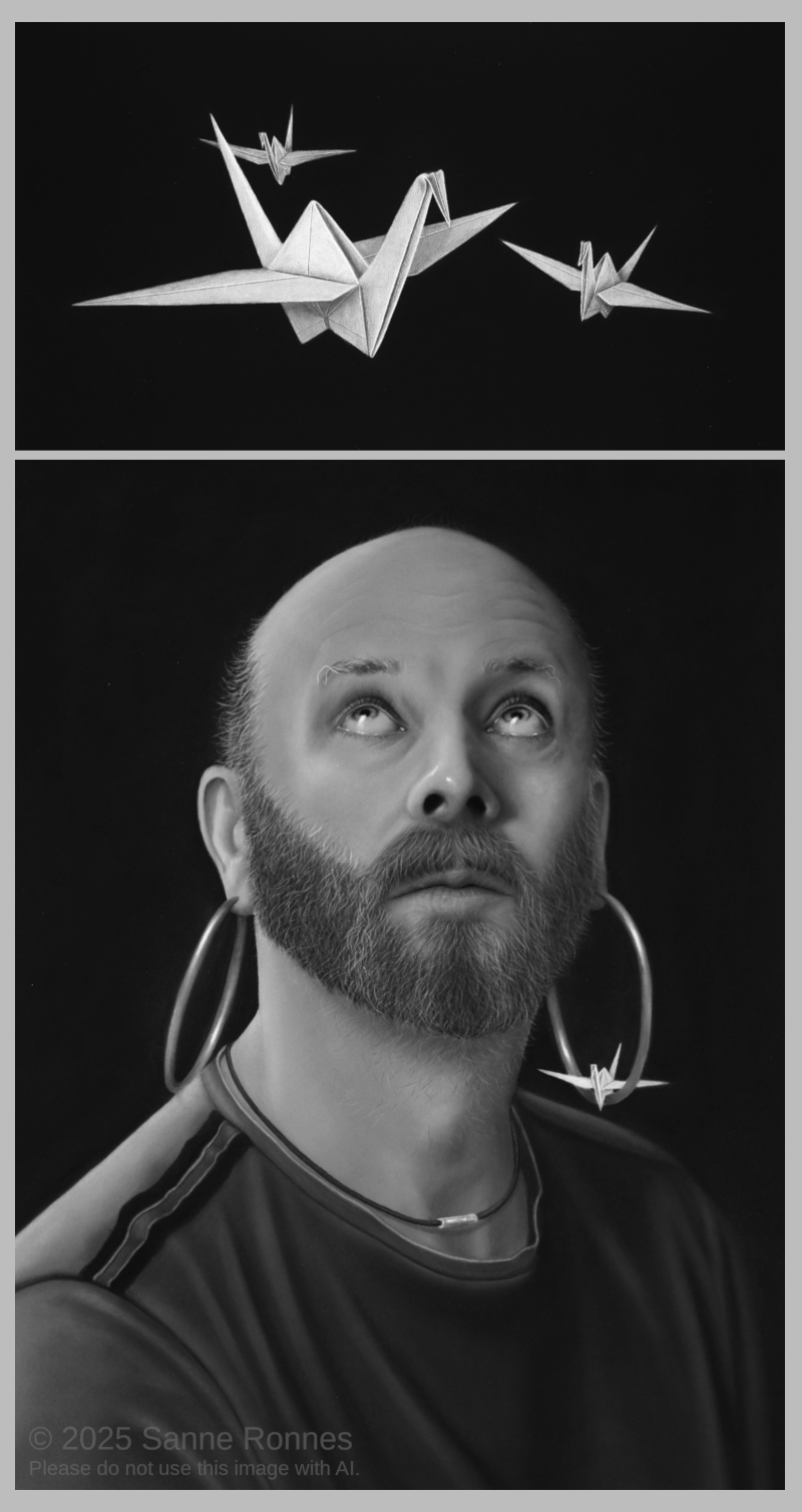 Man looking up to three origami cranes. Black and white.