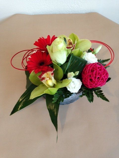 Composition basse composée de gerbéra rouge et de fleurs blanches