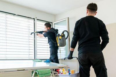 Leerer Essbereich mit polierten Holzböden, einer modernen dreiflammigen Pendelleuchte und grossen Glasschiebetüren.