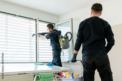 Leerer Essbereich mit polierten Holzböden, einer modernen dreiflammigen Pendelleuchte und grossen Glasschiebetüren.