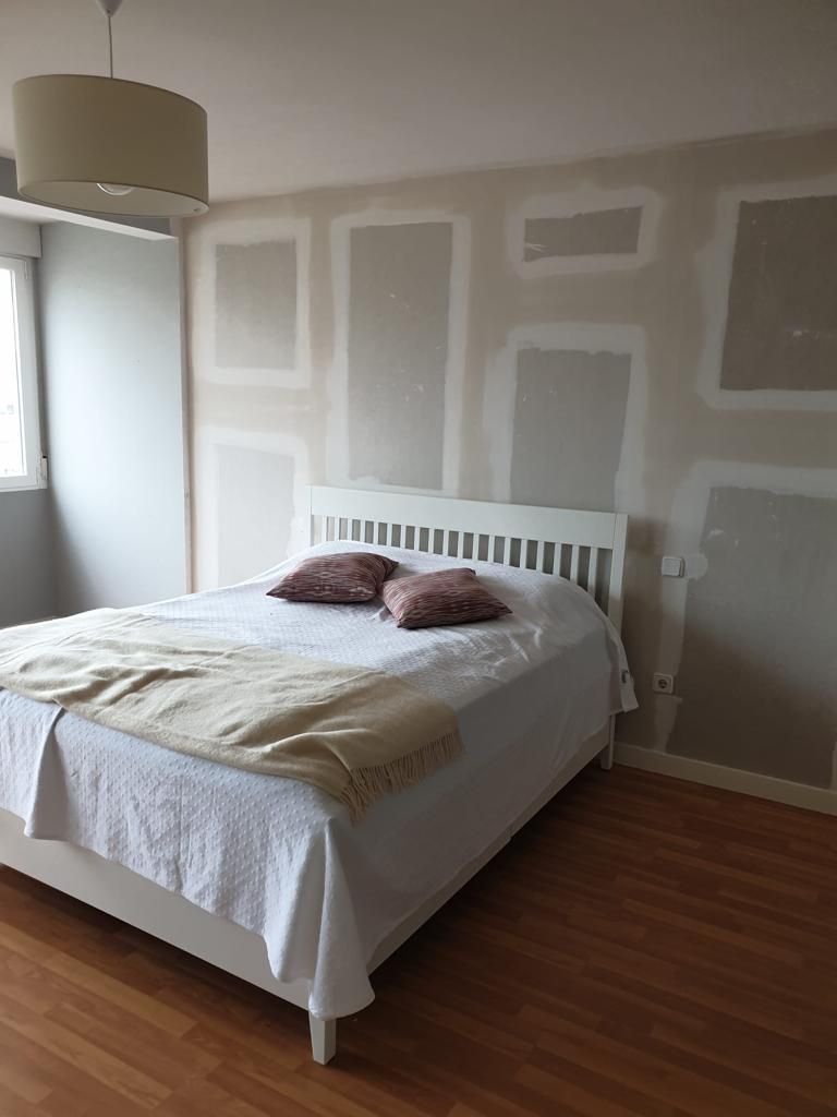 Interior de oficina con dos escritorios, computadoras y vista al exterior a través de puertas de vidrio esmerilado. Color neutro.