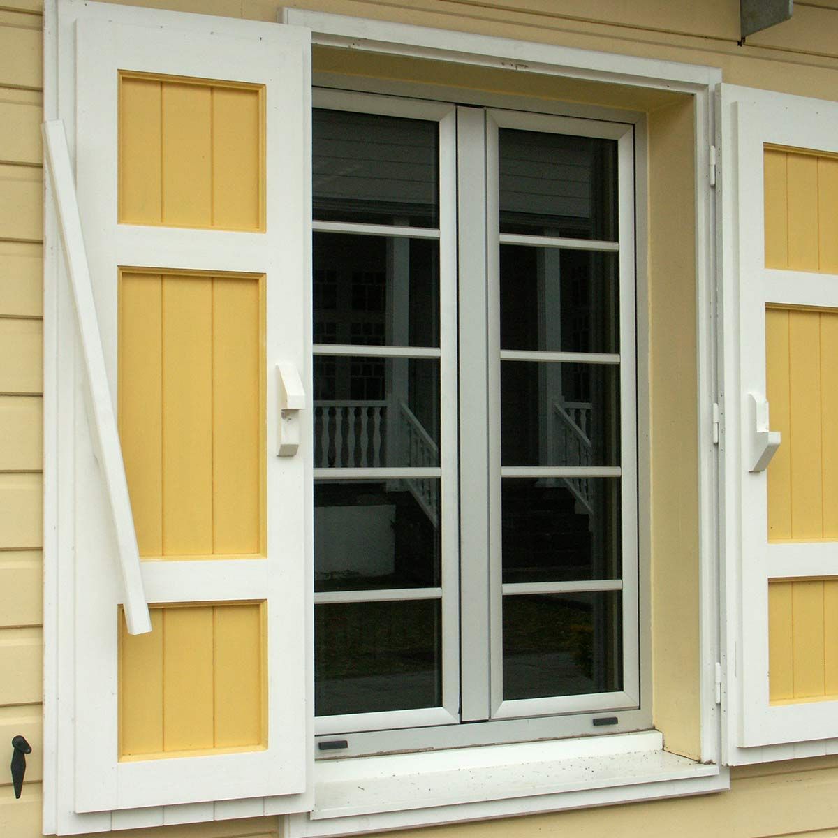 Fenêtre avec des volets jaunes et blancs