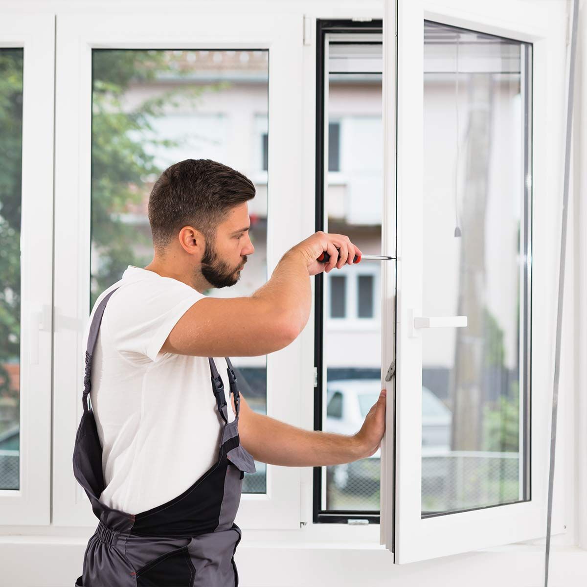 Artisan utilisant un tournevis sur un cadre de fenêtre