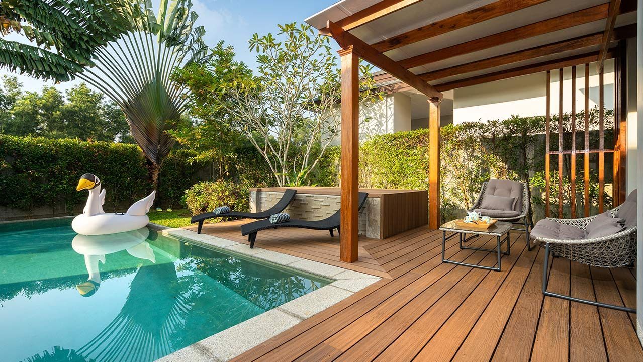 Piscine et terrasse couverte en bois avec transats