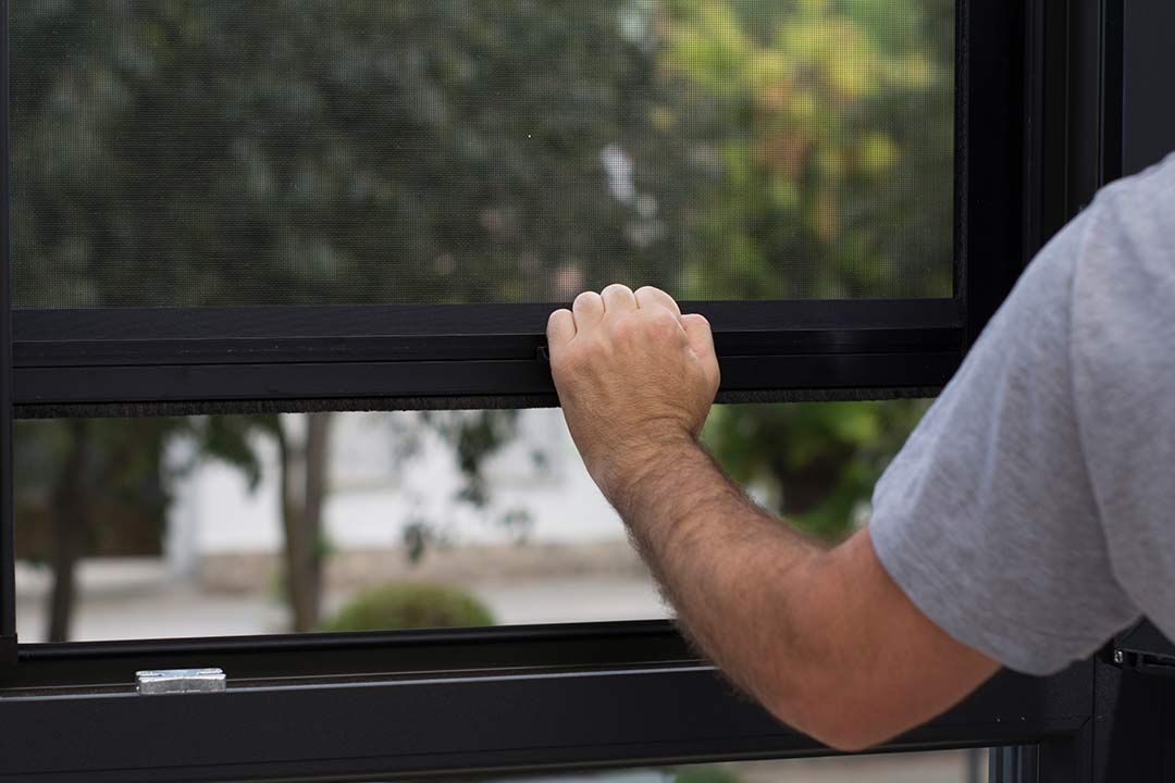 Homme qui ferme une moustiquaire