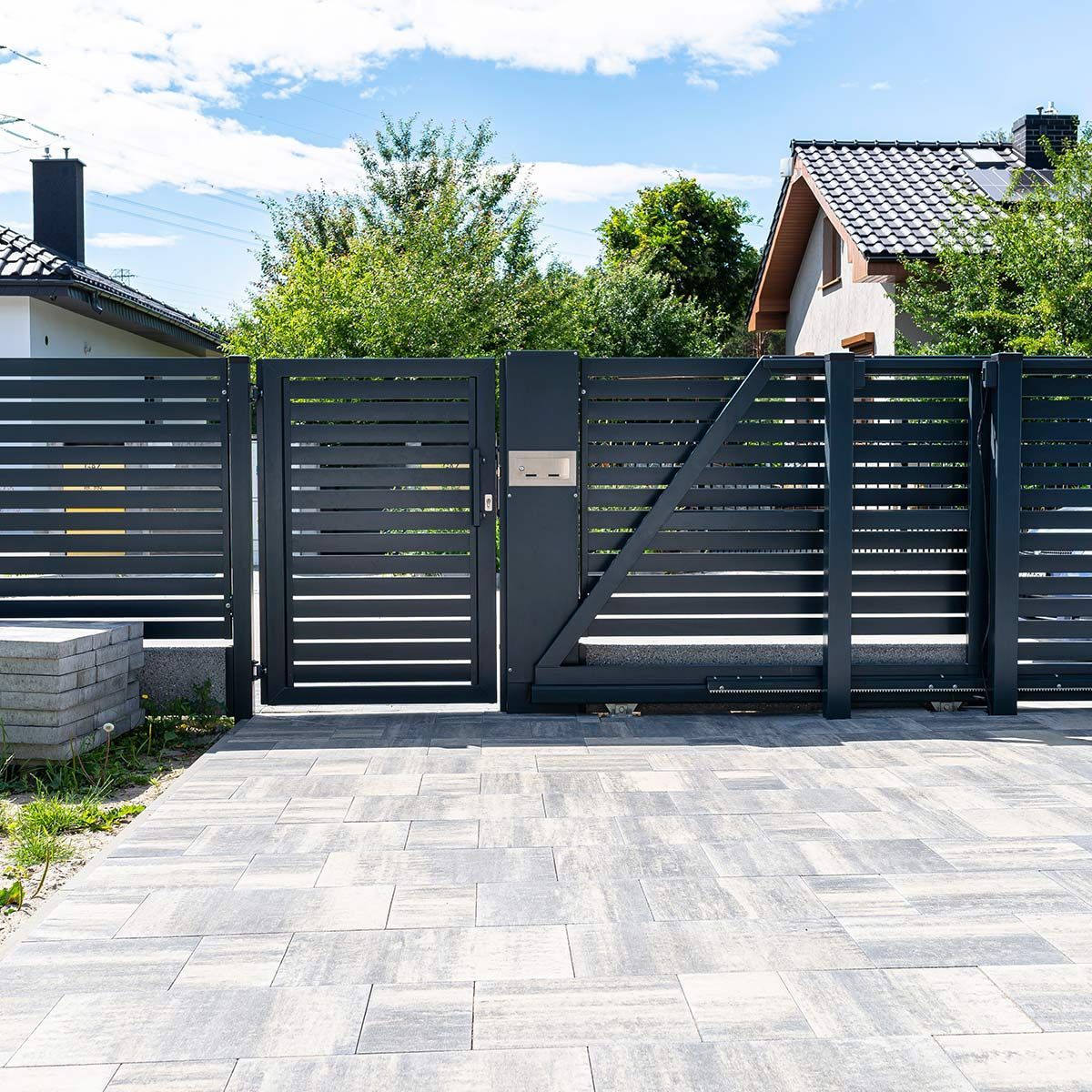 Portail de maison gris anthracite et allée carrelée