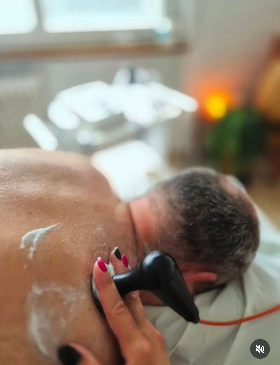 Strumenti per massaggi in legno e una bottiglia su uno scaffale.