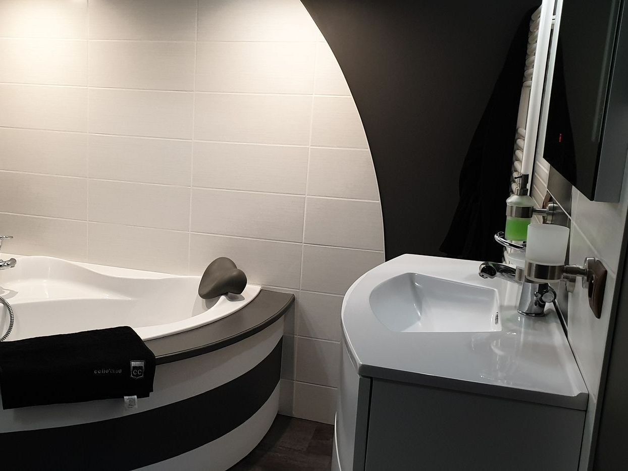 Baignoire avec un appuie-tête gris et serviette noire