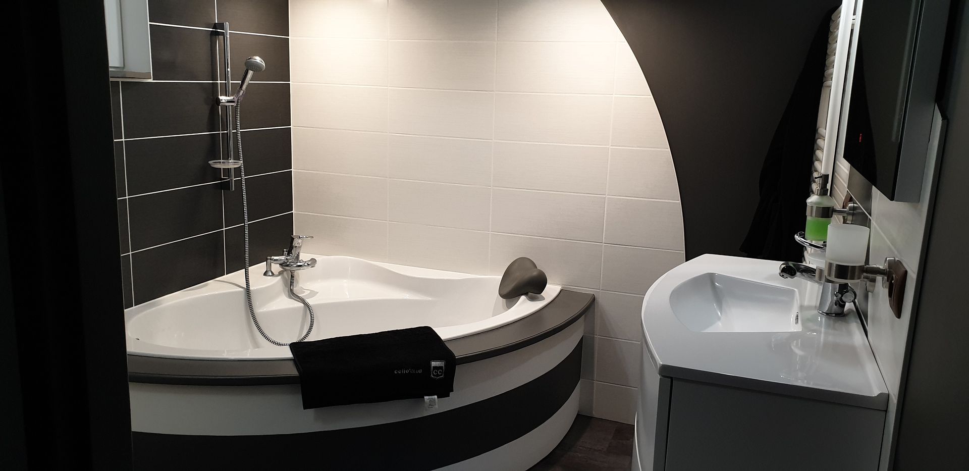 Salle de bains avec une baignoire et du carrelage mural noir et blanc