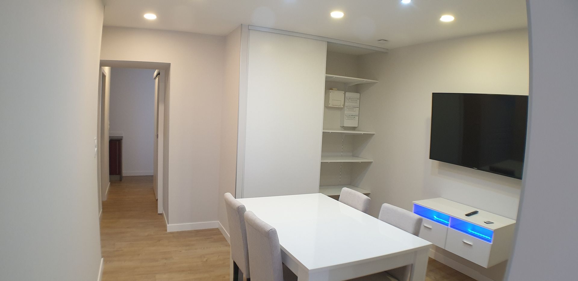 Une salle à manger avec des murs et des meubles peints en blanc