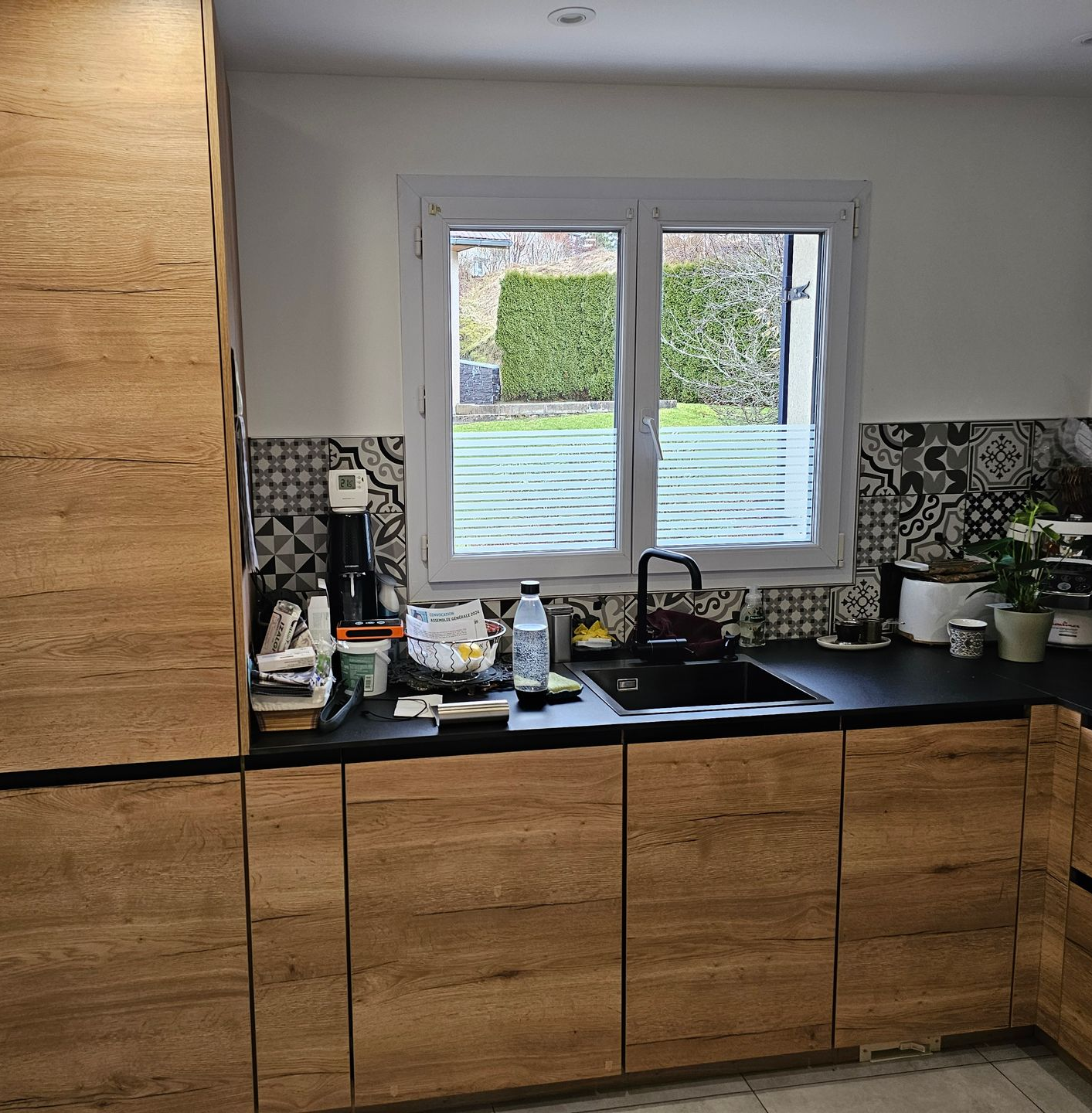 Cuisine avec des placards en bois, une fenêtre et de la lumière naturelle