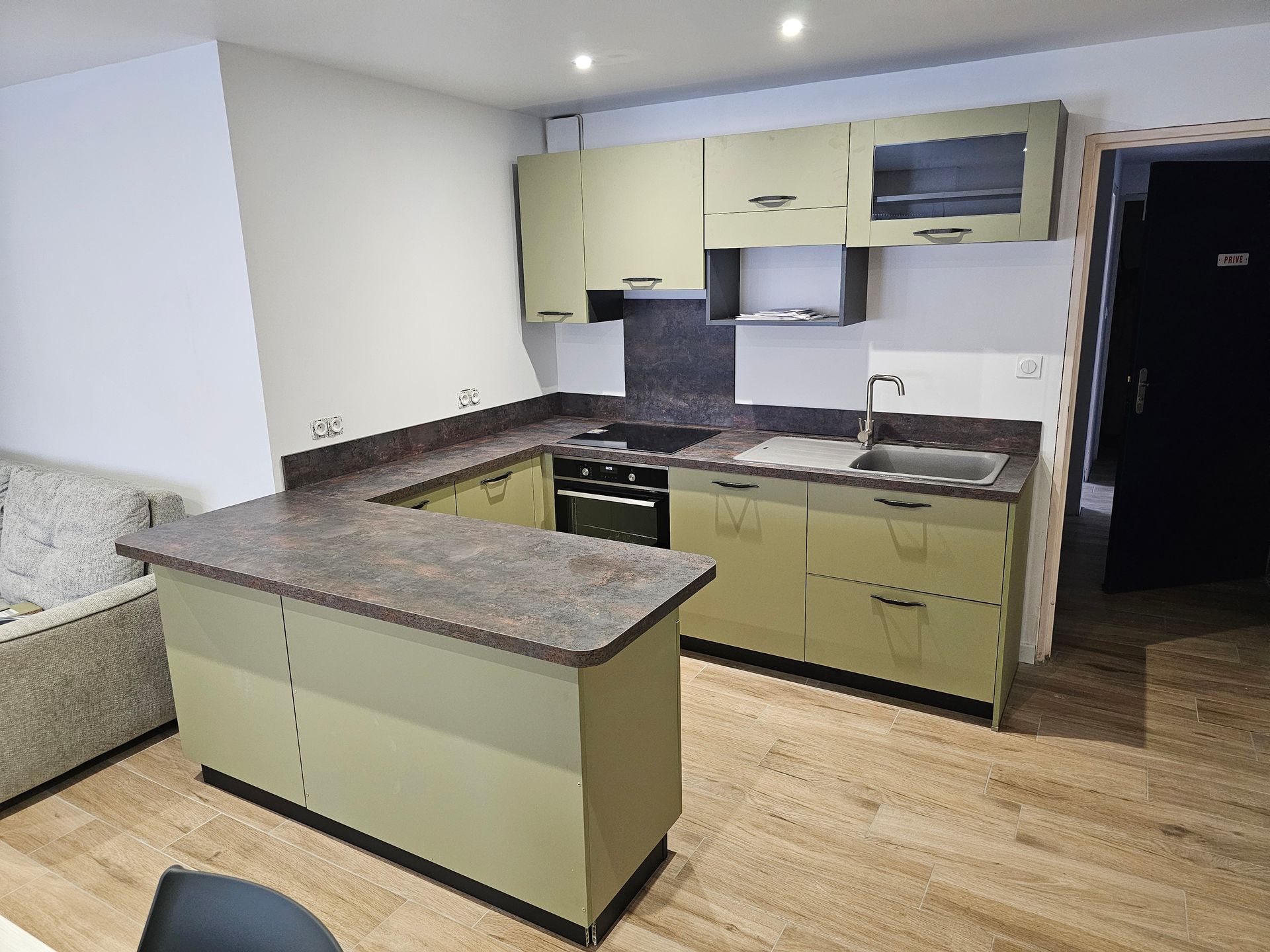 Cuisine moderne avec des meubles verts et un plan de travail foncé