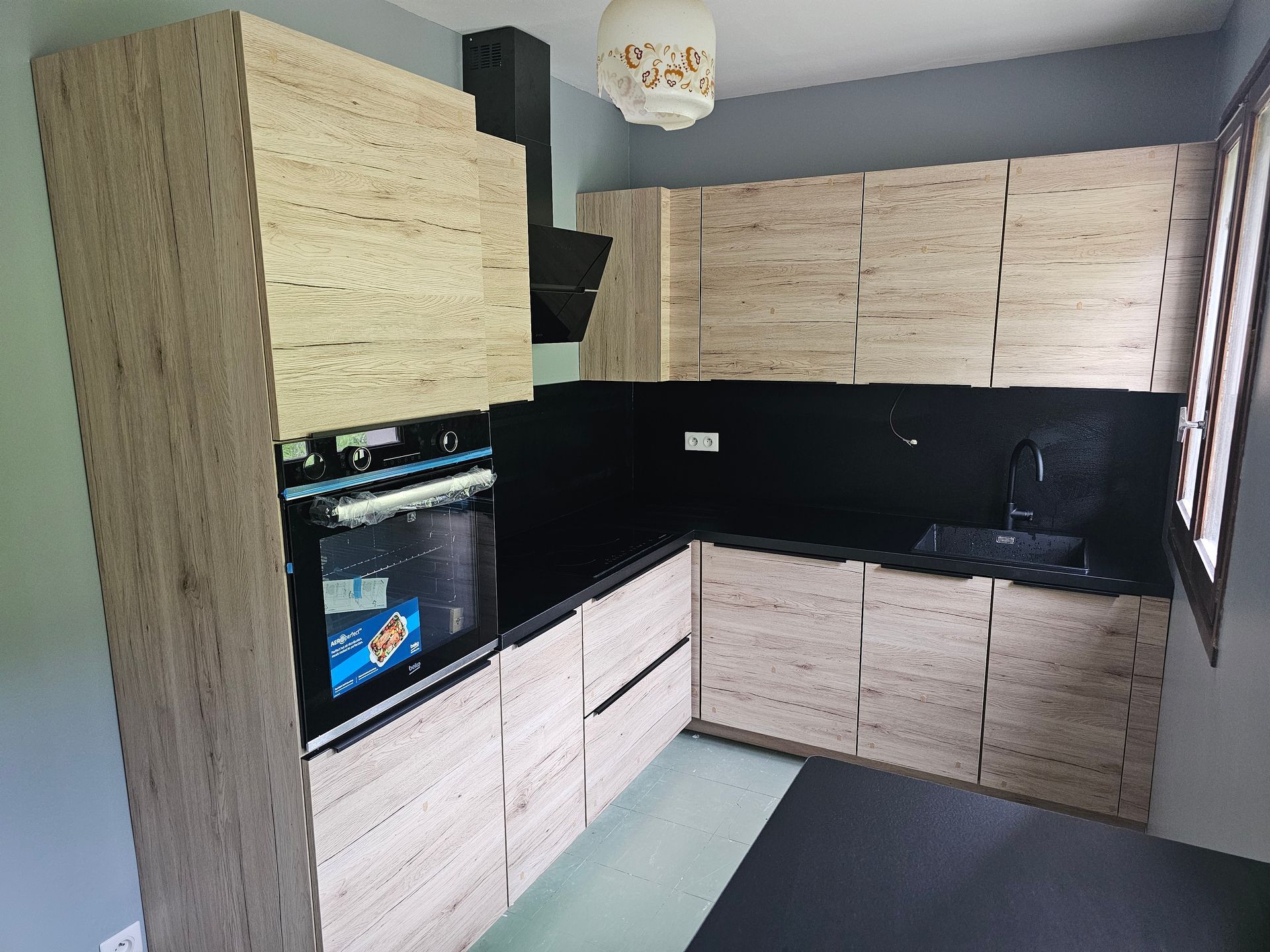 Cuisine avec un four encastré et un plan de travail noir