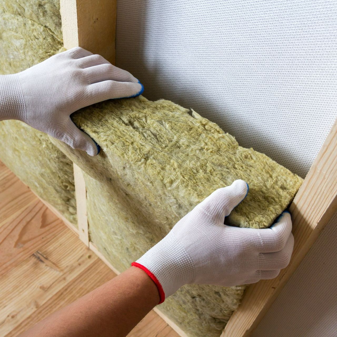Application de laine de verre avec des gants blancs
