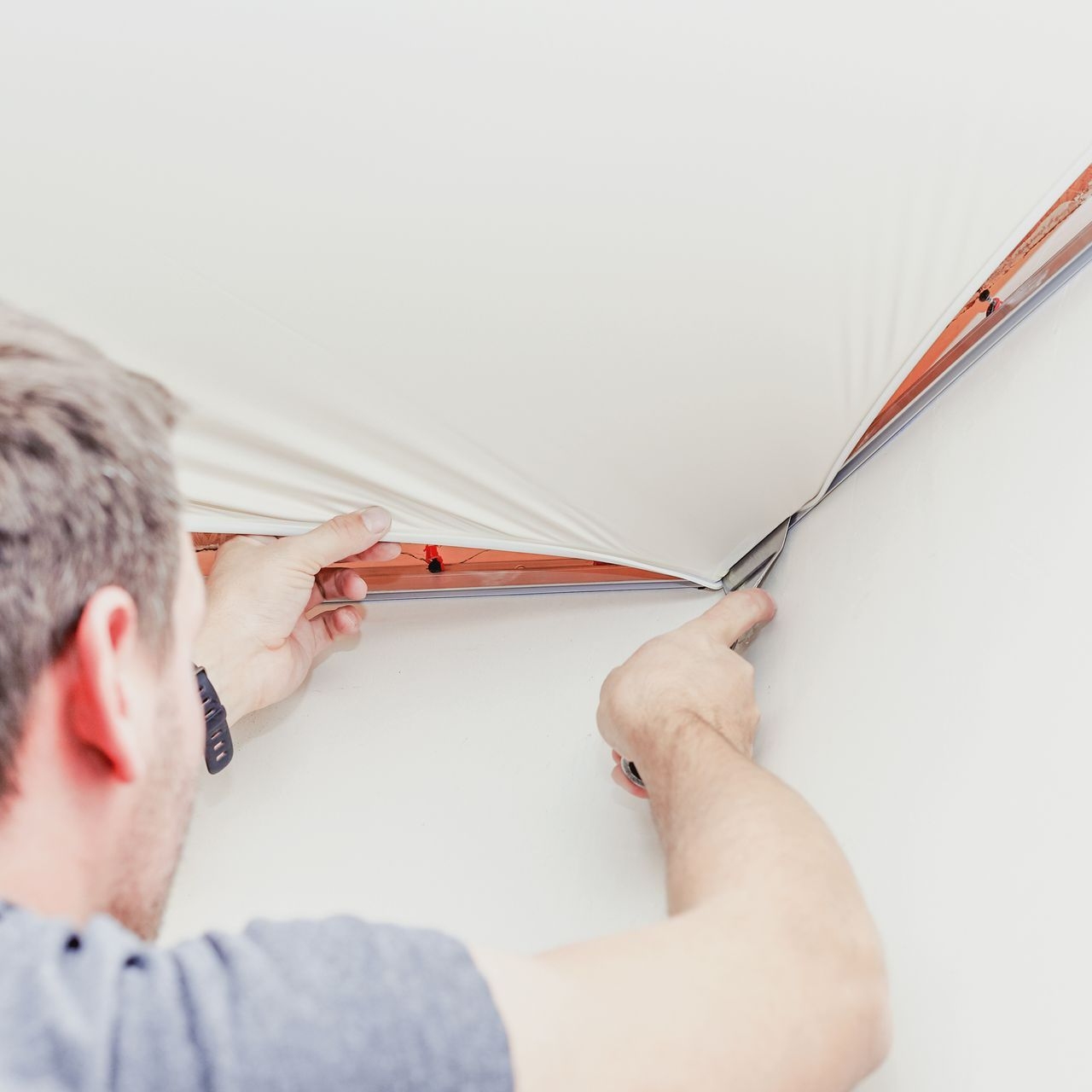 Un artisan réalise la pose d'un faux plafond