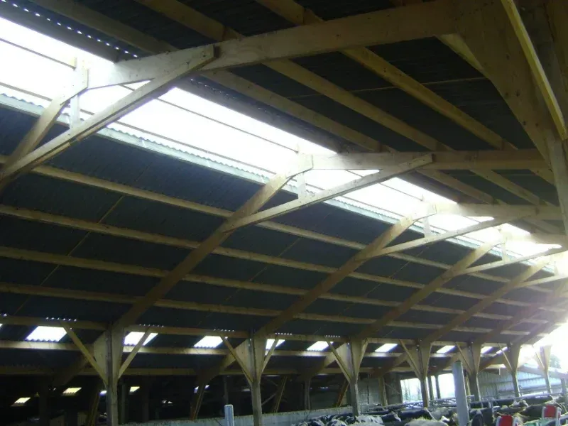 Haut plafond d'une grange, avec ses poutres de soutien en bois