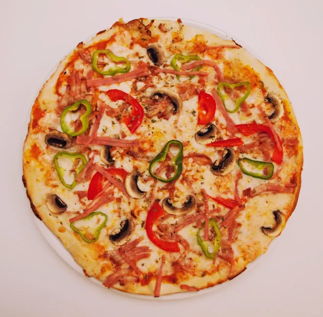 Una pizza redonda cubierta con queso fundido, salsa de tomate, champiñones en rodajas, pimientos verdes