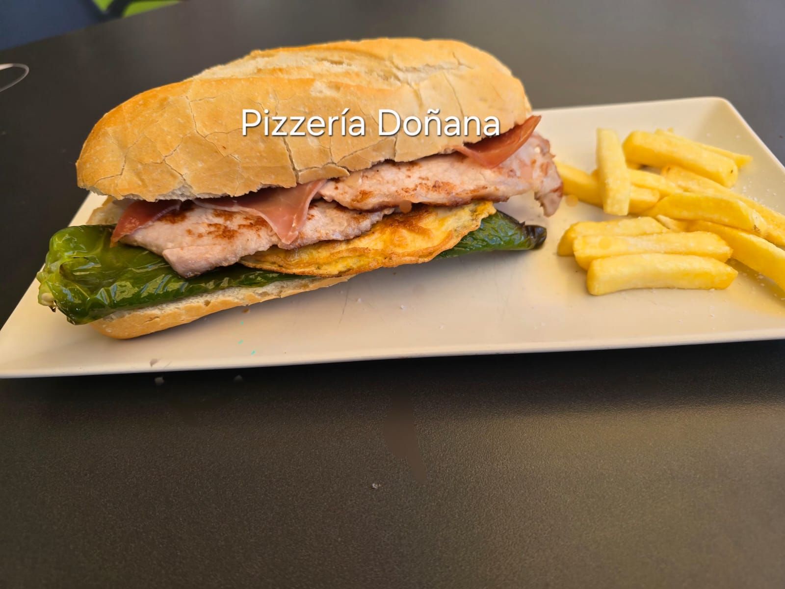 Primer plano de una jugosa hamburguesa con pan tostado, carne oscura de res, tocino, salsa de naranja y lechuga fresca.