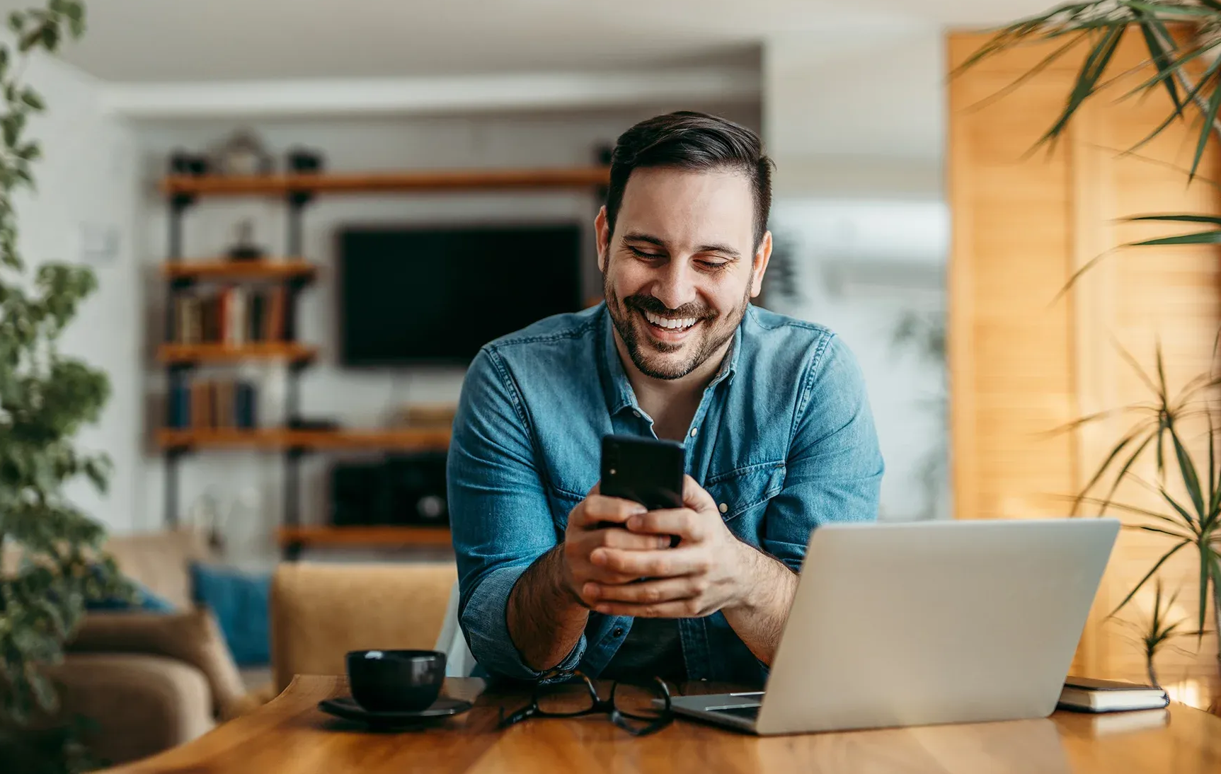 Persona rubia con uniforme azul sonriendo, inclinada sobre una mesa de masajes en un consultorio médico.