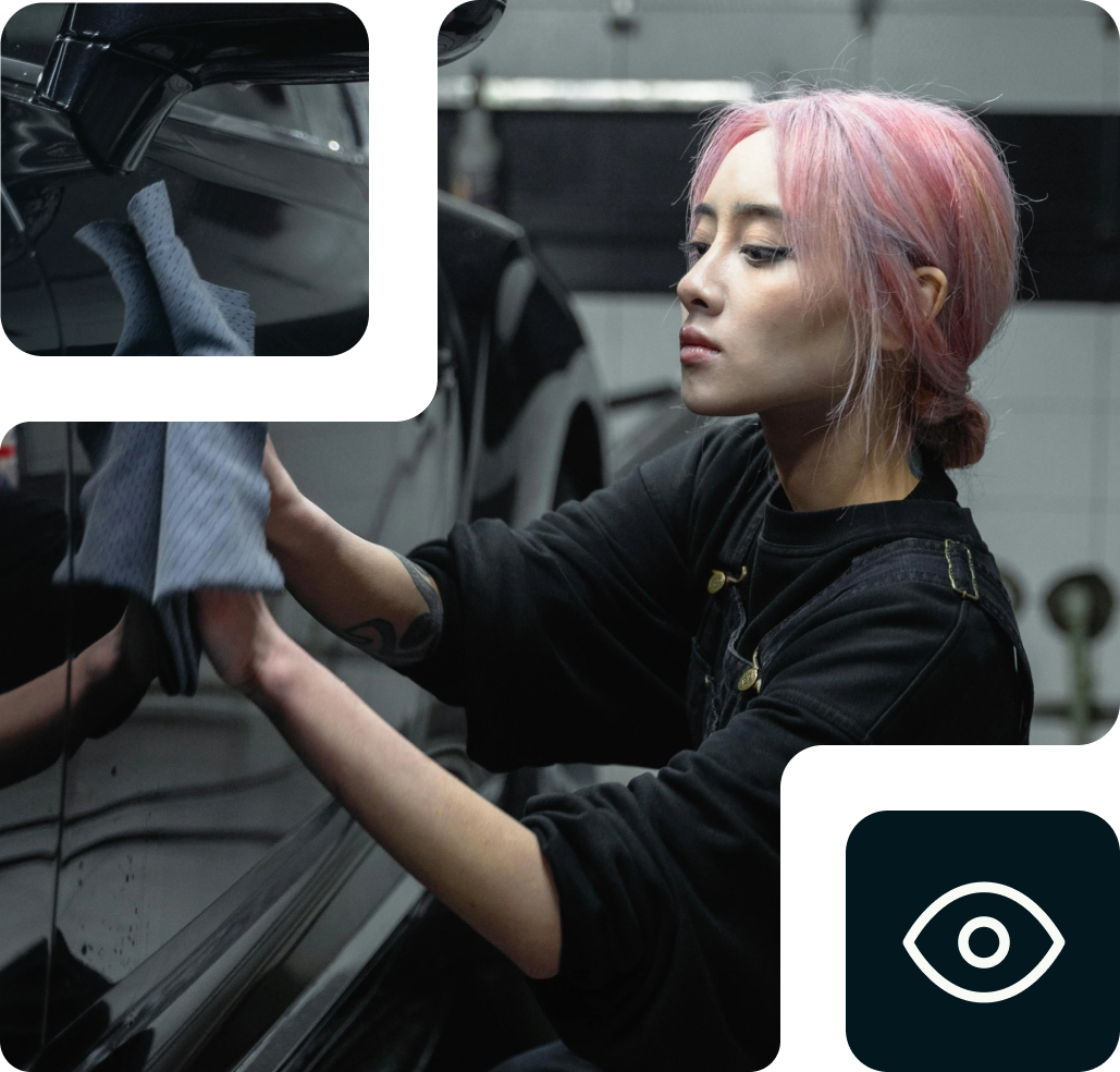 Mujer con el pelo rosa limpiando un coche con un paño de microfibra en un garaje.