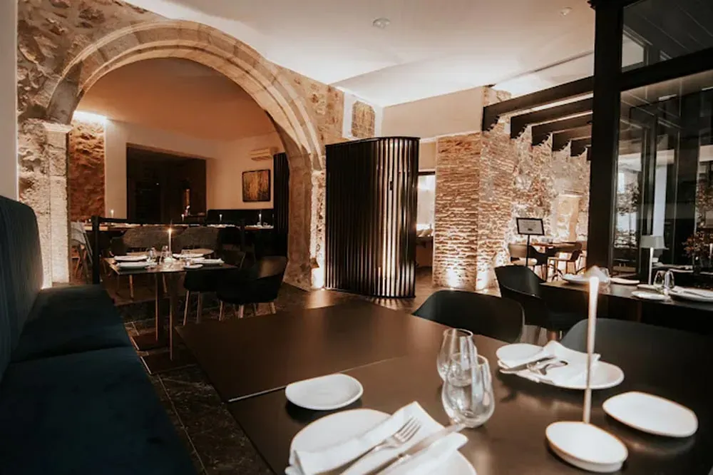 Un restaurante con muchas mesas, sillas y platos.