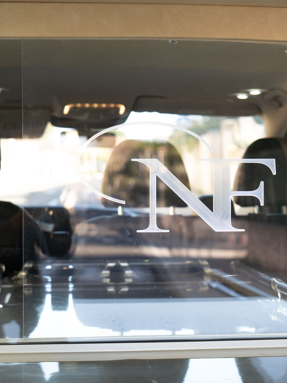 Logo des pompes funèbres sur la vitre arrière d'un corbillard.