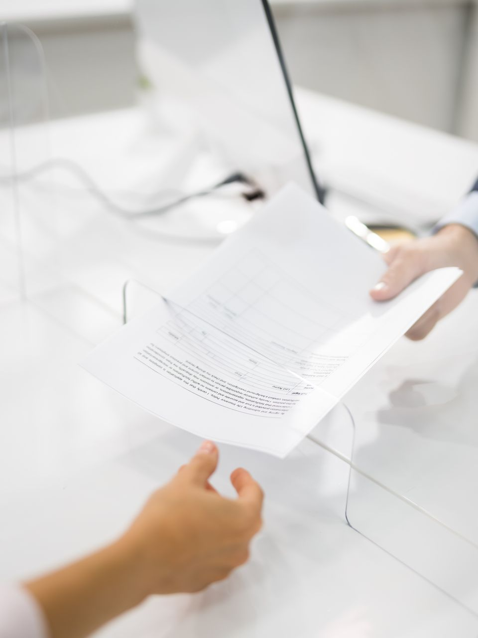 Une personne tent un document à une autre personnes.