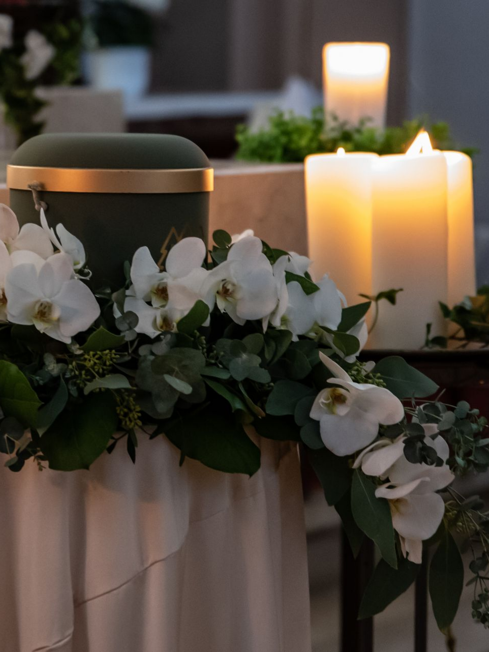 Une urne funéraire entourée de fleurs et de bougies.